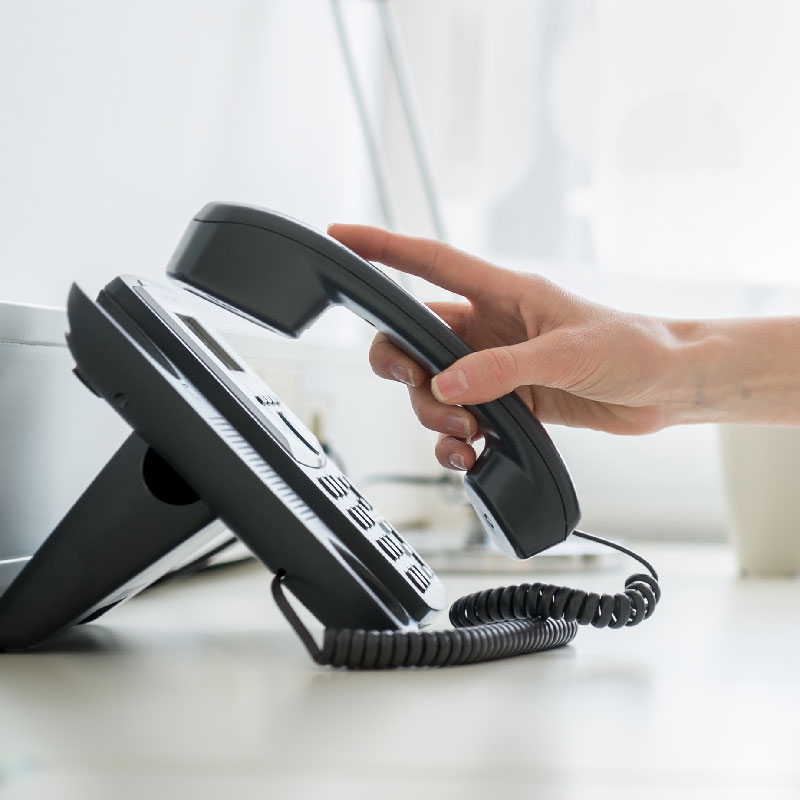 A photo of a person picking up a phone.